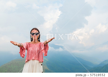 Beautiful happy young woman in mountains in the background of fog 57519552