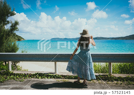 海とワンピースの女性後ろ姿 南国ビーチリゾート 奄美大島 の写真素材