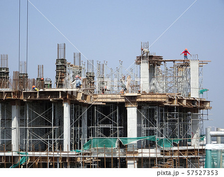 Construction workers working at height at the construction site. Using scaffolding as the temporary platform to work. Construction workers working at height at the construction site. Using scaffolding as the temporary platform to work. 57527353