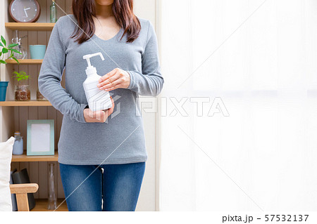 アルコール除菌する女性　手指消毒スプレー 57532137