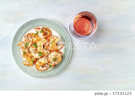 Cooked shrimps, shot from the top on a rustic wooden background with a glass of rose wine and a 57533125