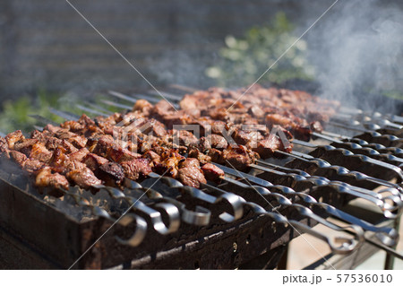 Meat on skewers is roasted on fire. Grilled cubes 57536010