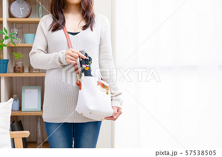 折り畳み傘を鞄に入れる妊婦 57538505