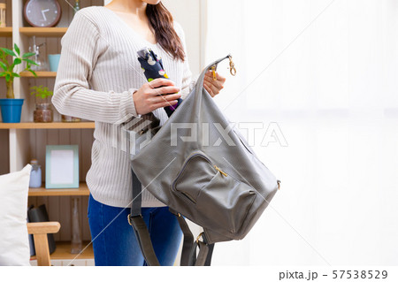 折りたたみ傘をリュックに入れる女性 57538529