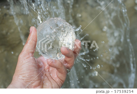 Water fall on the lansball holding in hand 57539254