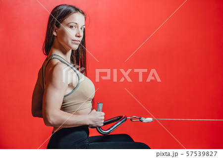 Beautiful sport girl is engaged on a simulator in the gym. Pretty girl with the beautiful tightened 57539827