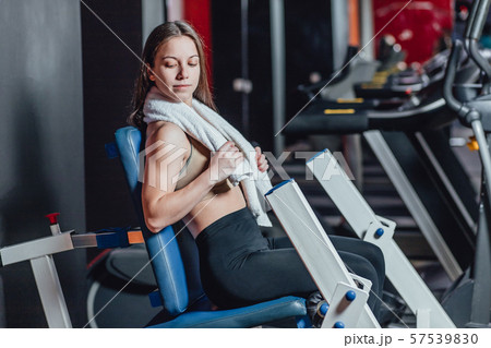 Beautiful sport girl is engaged on a simulator in the gym. Pretty girl with the beautiful tightened 57539830