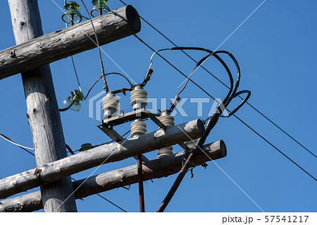 Old wooden high voltage electric transmission tower with wires on insulators 57541217