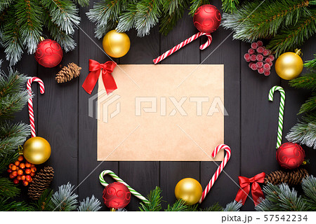 Christmas or New Year decoration background: fir-tree branches, colorful balls, candy cane on black background. Top view with copy space. Falt lay. Christmas or New Year decoration background: fir-tree branches, colorful balls, candy cane on black background. Top view with copy space. Falt lay. 57542234