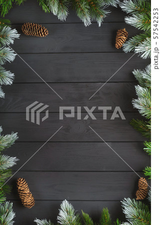 Christmas or New Year decoration background: fir-tree branches, colorful balls, candy cane on black background. Top view with copy space. Falt lay. 57542253