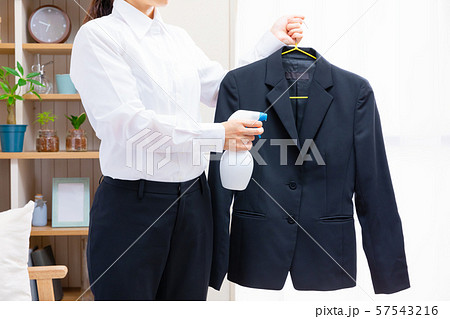 ジャケットにスプレーするビジネスウーマン 57543216