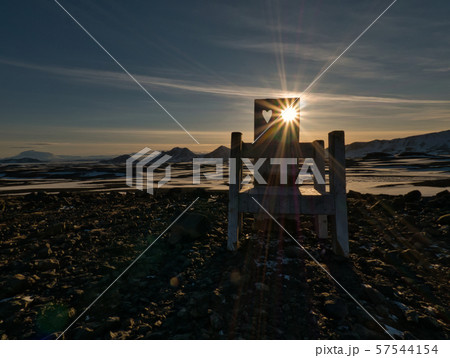 The sun shines through the hole in a chair 57544154