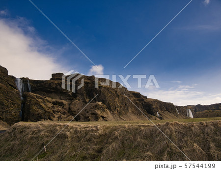 A hill with several waterfalls in the background 57544199