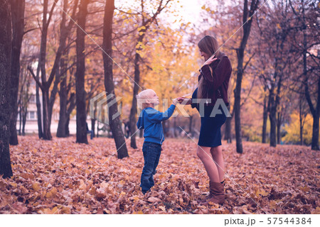 Little blond boy gives his pregnant mother yellow 57544384