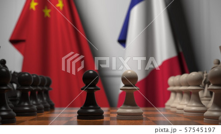 Flags of China and France behind chess board. The first pawn moves in the beginning of the game 57545197