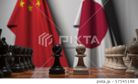 Flags of China and Japan behind chess board. The first pawn moves in the beginning of the game 57545199