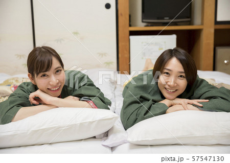 旅館部屋の布団に寝転がる女性　女子旅イメージ　GoToトラベルキャンペーン 57547130