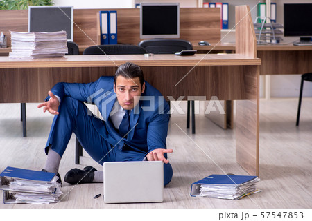 Young male employee and too many work in the office Young male employee and too many work in the office 57547853