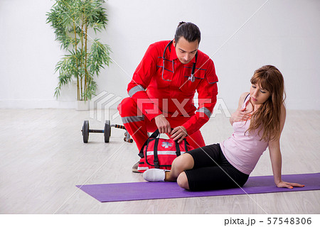 Paramedic in red visiting young woman in gym 57548306