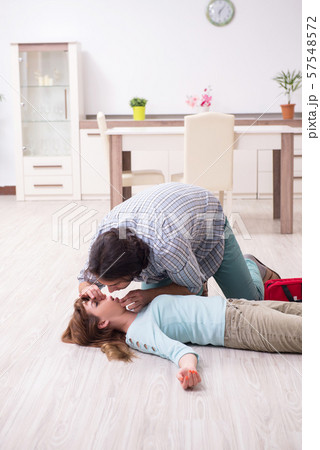 Young couple in first aid concept at home 57548572