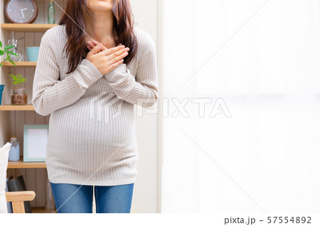 胸を抑える妊婦　様々な疾患 57554892