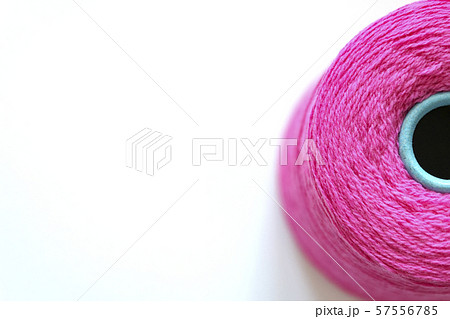 Bobbin of fuchsia threads for hand and machine knitting close-up. Background top view, space for Bobbin of fuchsia threads for hand and machine knitting close-up. Background top view, space for 57556785