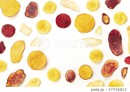 Dry fruit and vegetable chips, healthy vegan snack, an organic food flat lay pattern on a white Dry fruit and vegetable chips, healthy vegan snack, an organic food flat lay pattern on a white 57556812