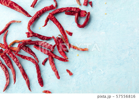 Dry red hot peppers on a blue background, shot from the top with a place for text Dry red hot peppers on a blue background, shot from the top with a place for text 57556816