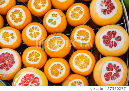 Background of fresh ripe orange and grapefruit with incision on the counter in the street market. 57560277
