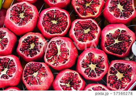 Background of fresh ripe pomegranates with incision on the counter in the street market. 57560278