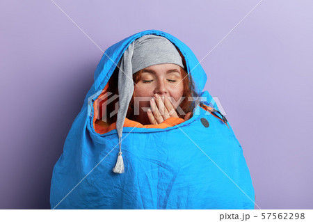 funny young tourist with closed eyes, palm on her mouth, 57562298