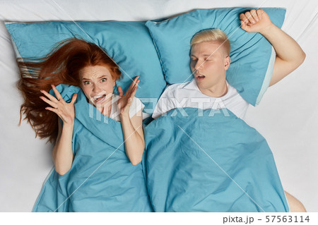 Awake frustrated woman lying in white bedroom Awake frustrated woman lying in white bedroom 57563114
