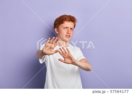young scared man shows refusal gesture 57564177