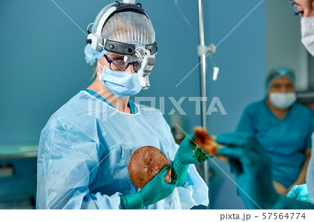 Surgeon preparing breast silicone implant for the operation Surgeon preparing breast silicone implant for the operation 57564774