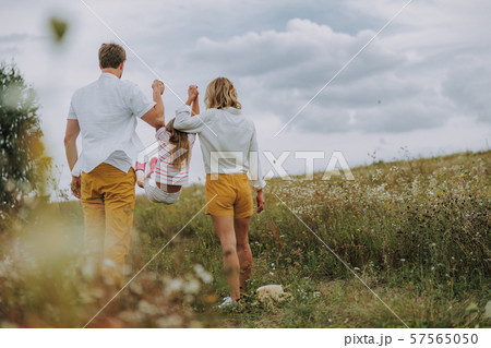 Parents raising their daughter by the hands Parents raising their daughter by the hands 57565050