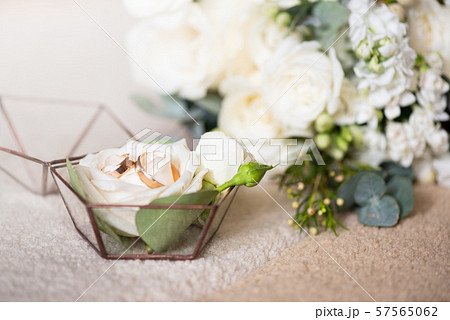 Two wedding rings in beautiful box and bouquet of flowers. Themes of engagement, declaration of love Two wedding rings in beautiful box and bouquet of flowers. Themes of engagement, declaration of love 57565062
