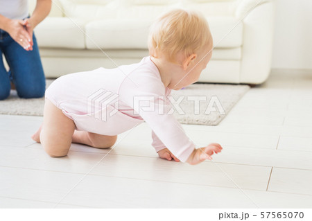 Smiling crawling baby girl at home on floor 57565070