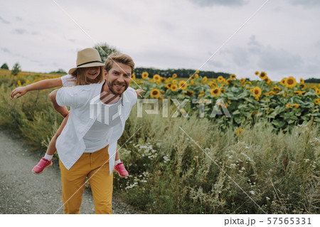 Cheerful daughter spending time with her dad near field 57565331