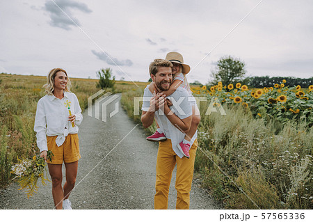 Little daughter spending time with her parents near field 57565336