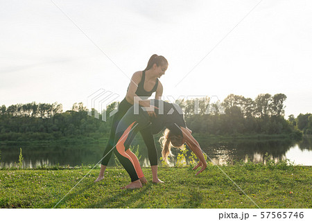Small female fitness group doing yoga in park on a sunny day 57565746