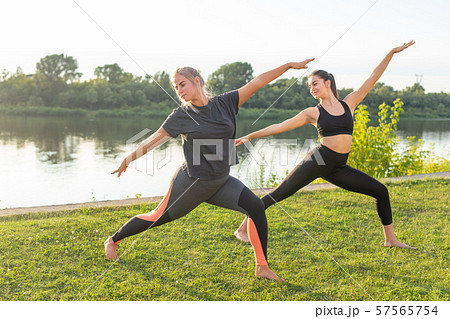 Small female fitness group doing yoga in park on a sunny day Small female fitness group doing yoga in park on a sunny day 57565754