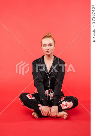 Young girl sitting on floor and meditating with 57567407