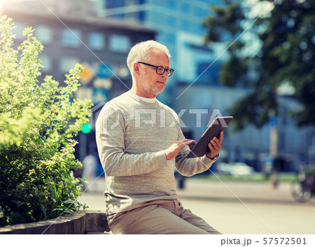 senior man with tablet pc on city street senior man with tablet pc on city street 57572501