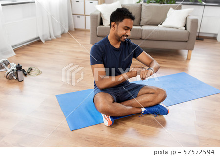 smiling indian man with fitness tracker at home 57572594