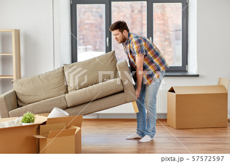 man moving sofa at new home 57572597