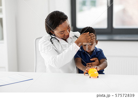 doctor with measuring baby's temperature at clinic 57572839