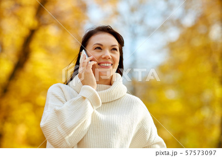 woman calling on smartphone in autumn park woman calling on smartphone in autumn park 57573097