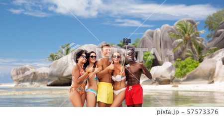 friends taking selfie on beach and show thumbs up 57573376
