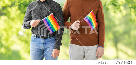 close up of male couple with gay pride flags 57573604