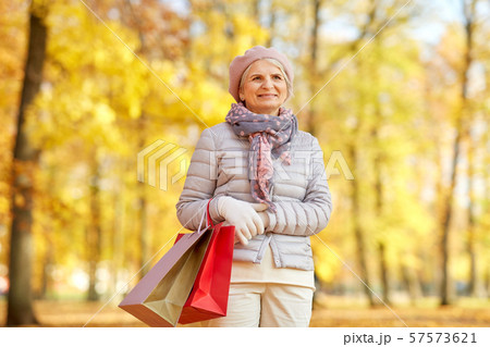 senior woman with shopping bags at autumn park senior woman with shopping bags at autumn park 57573621